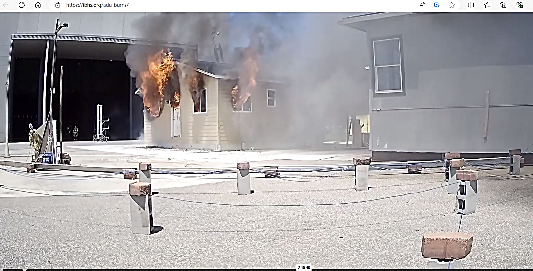 Photo of the ADU during the burn experiment. Flames and smoke can be seen coming off of the ADU.