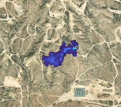 Blue and red image of a methane plume over brown terrain.