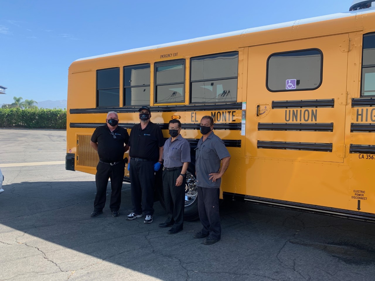 4 El Monte Unified High School Staff pose next to new electric school bus