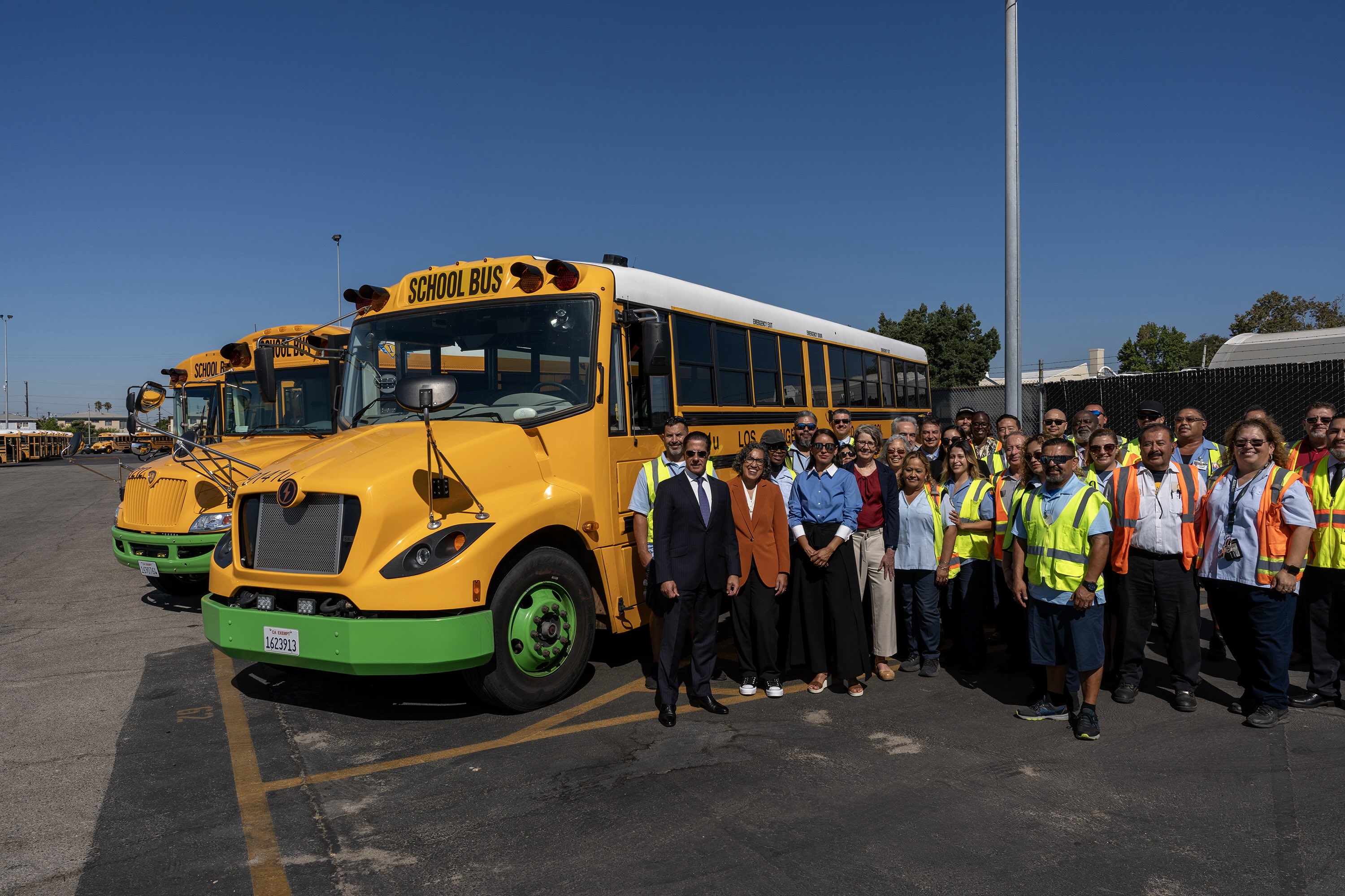 Staff and drivers next to school buses