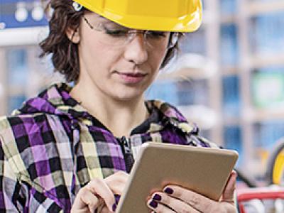 Photo of female technician taking notes in an industrial control room