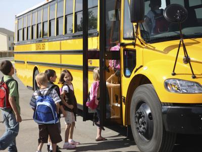 children getting into school bus